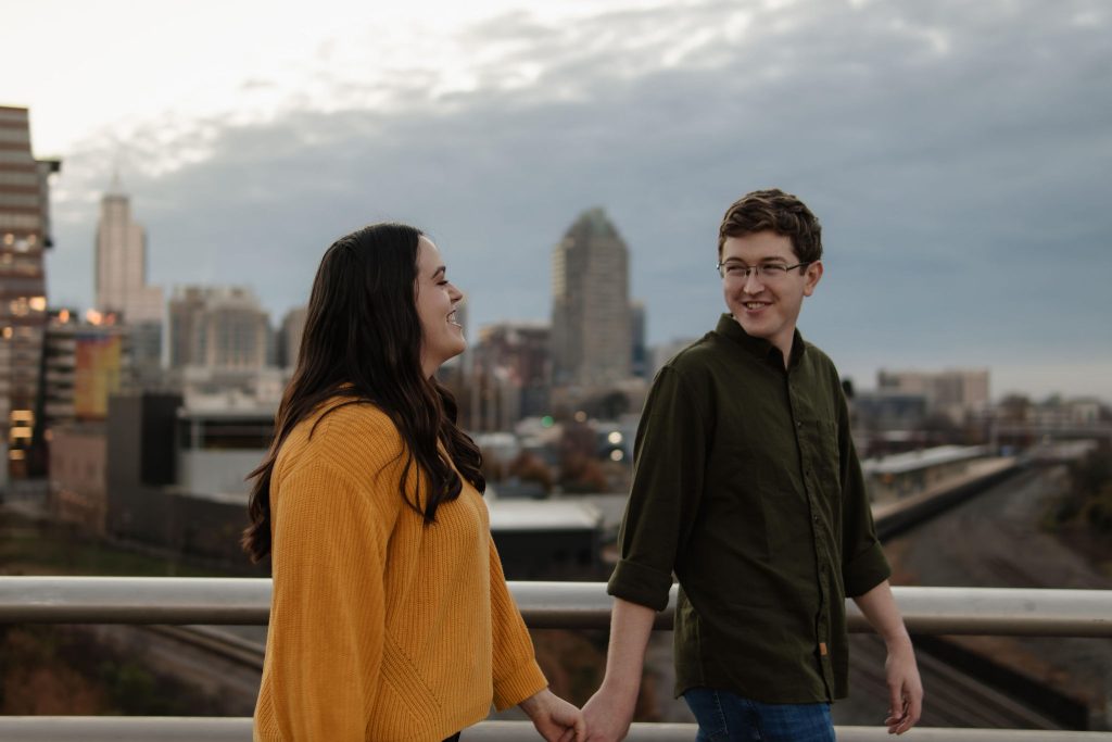 Couple walking on Boylan Bridge In Raleigh NC - Downtown Raleigh NC Engagement Session