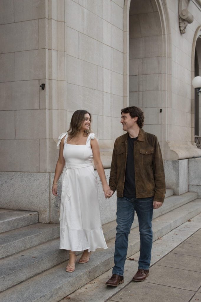 Couple walking while looking at each other in downtown Raleigh NC - Engagement Session Amelia and Matt Photo