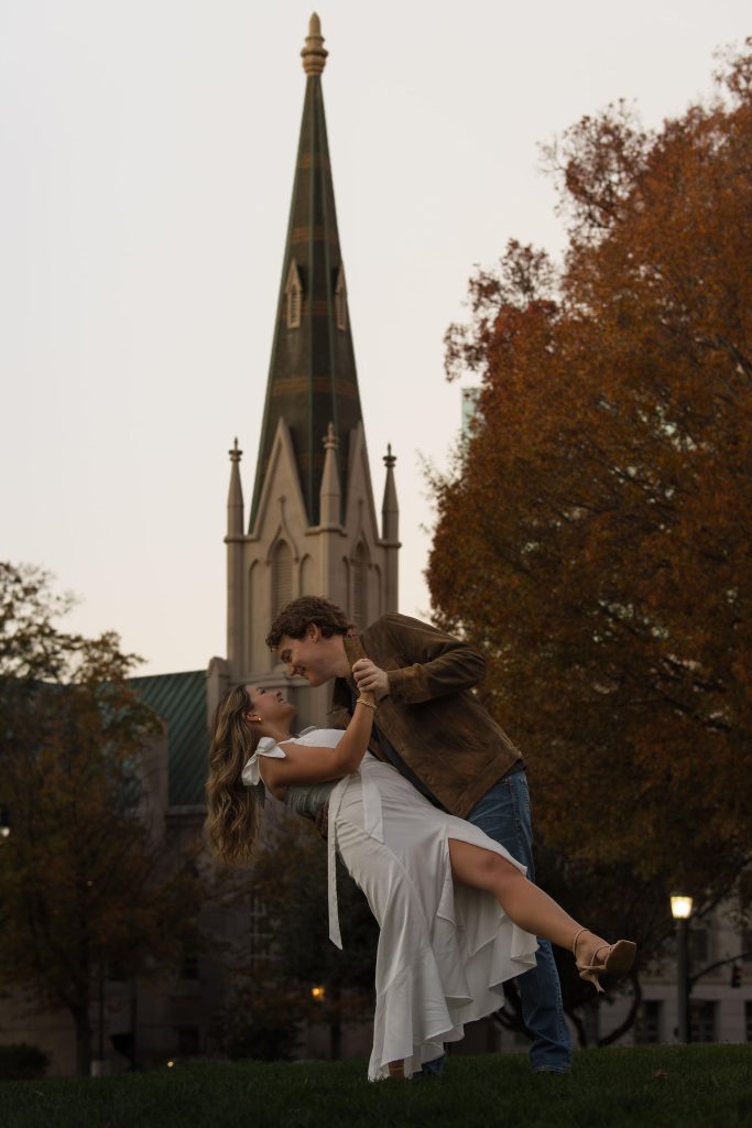 Couple doing a dip in downtown Raleigh NC in front of a church - Engagement Session