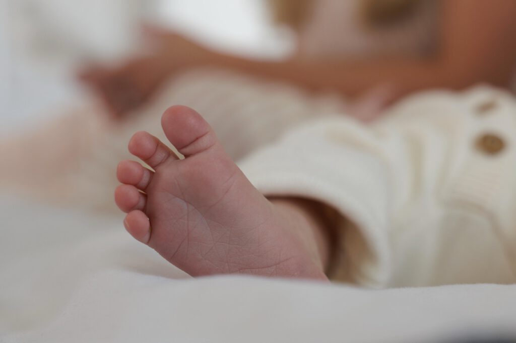 The tiny foot of a newborn baby sitting in their crib