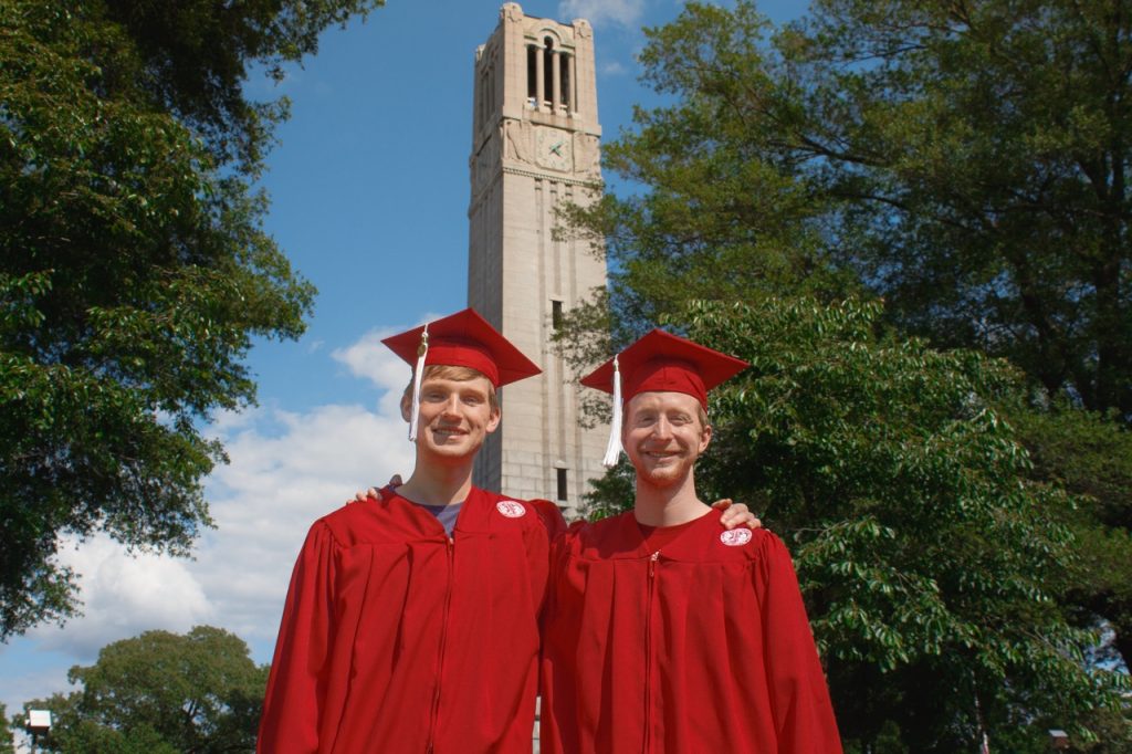 Two NC State Undergraduate Students posing in front of the Bell Tower for a graduation Photo Session with Amelia and Matt Photo in Raleigh NC
