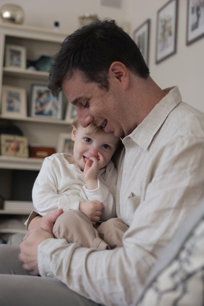 A dad tickling his son in an at home photography session in durham NC