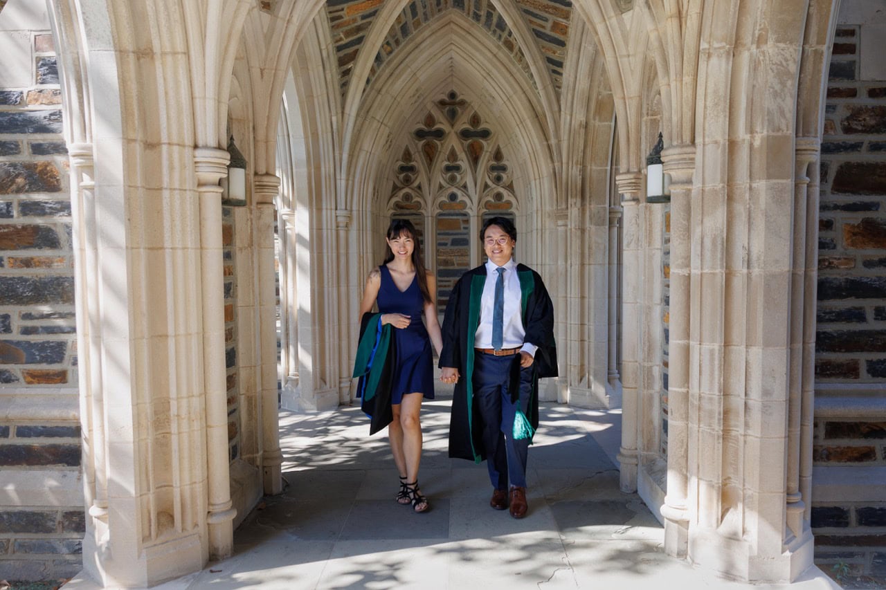 Couple walking while holding hands in the Duke Chapel during a Doctoral Graduation Session in Durham NC