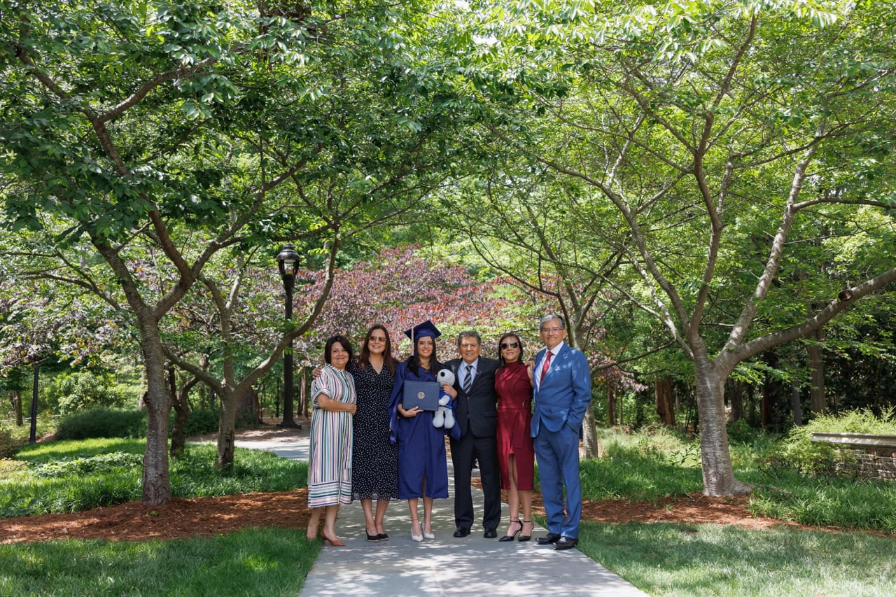 Family posing with their daughter graduating from Duke University posing near the chapel in Durham NC