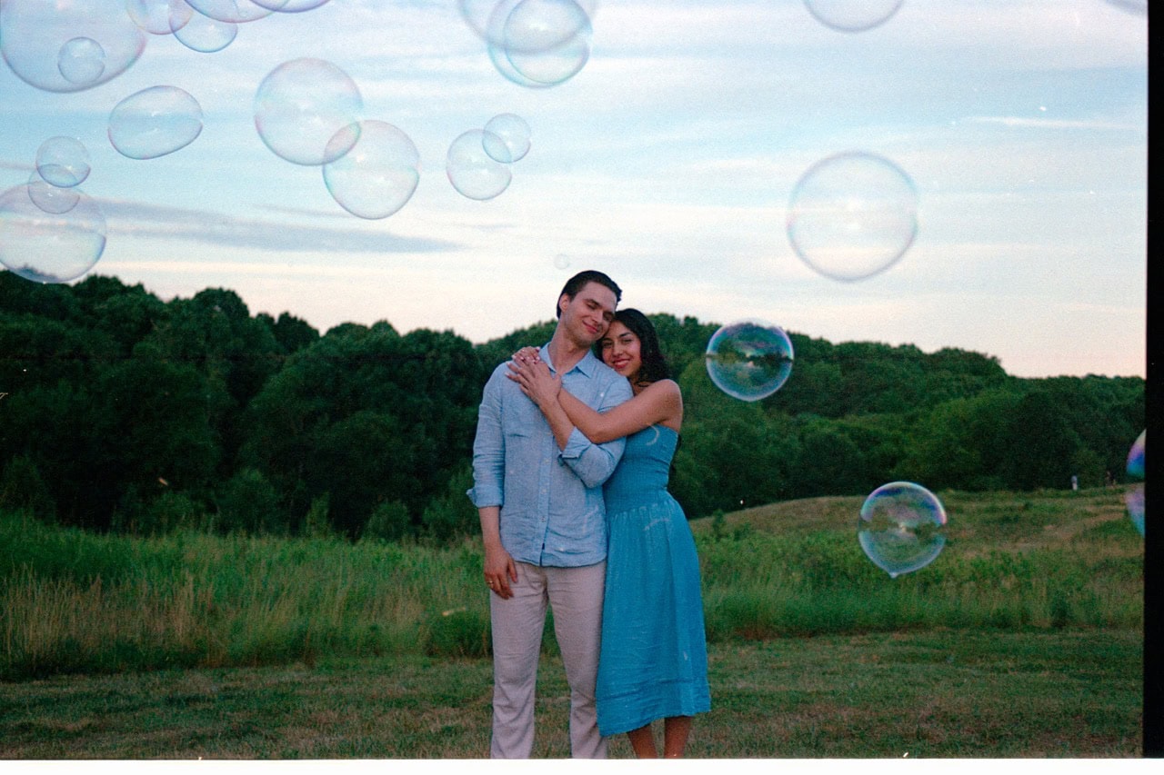 A 35mm film photograph of a couple at the NCMA with bubbles floating in the air.