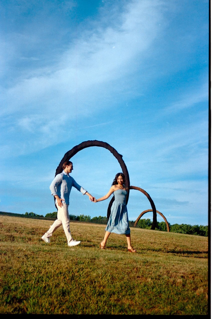 a 35mm film photograph of a couple in front of the gyre statues at the NC museum of art in raleigh