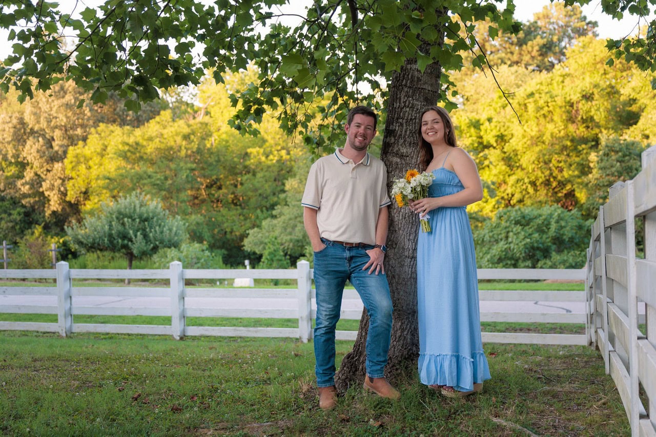 couple leaning on a tree at the historic oak view park in Raleigh NC at sunset