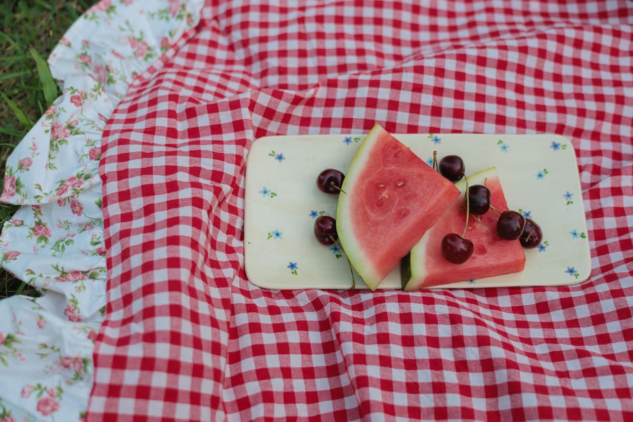 detail shot of cherries and watermelon on a picnic blanket 