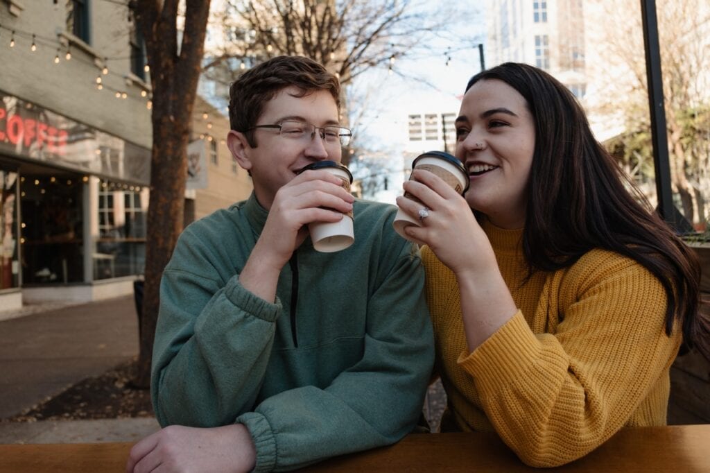 Couple laughing at Sir Walter Coffee in downtown Raleigh NC during their engagement session with Amelia and Matt Photo