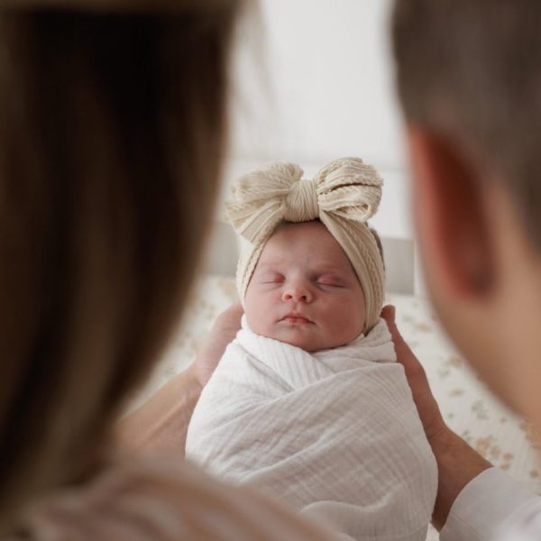 A view between the heads of mom and dad as they look down at their newborn baby. this image is stylized and artistic. Photographed by Amelia and Matt photo during an In-home newborn session in Raleigh NC