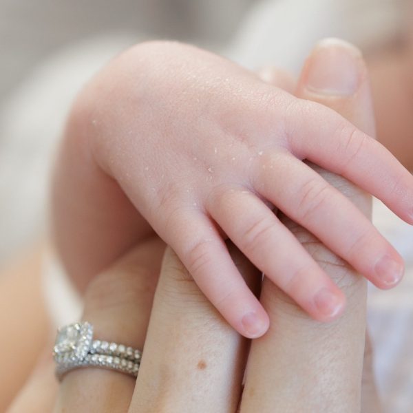 a small newborn hand holding his moms finger during an at home newborn photography session in Raleigh NC