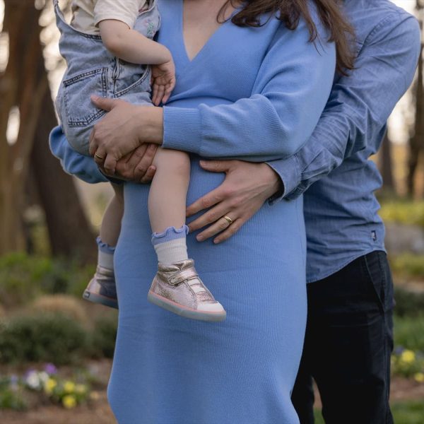 A family posing for maternity photos at WRAL Azalea garden in Raleigh NC